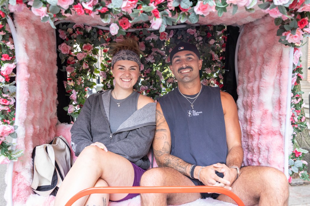 Couple on a flower-decorated pedicab.