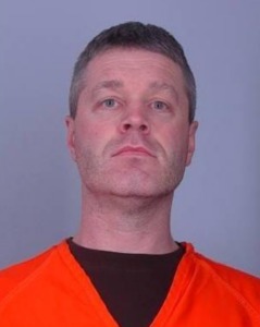 Mugshot of a man in an orange jumpsuit.