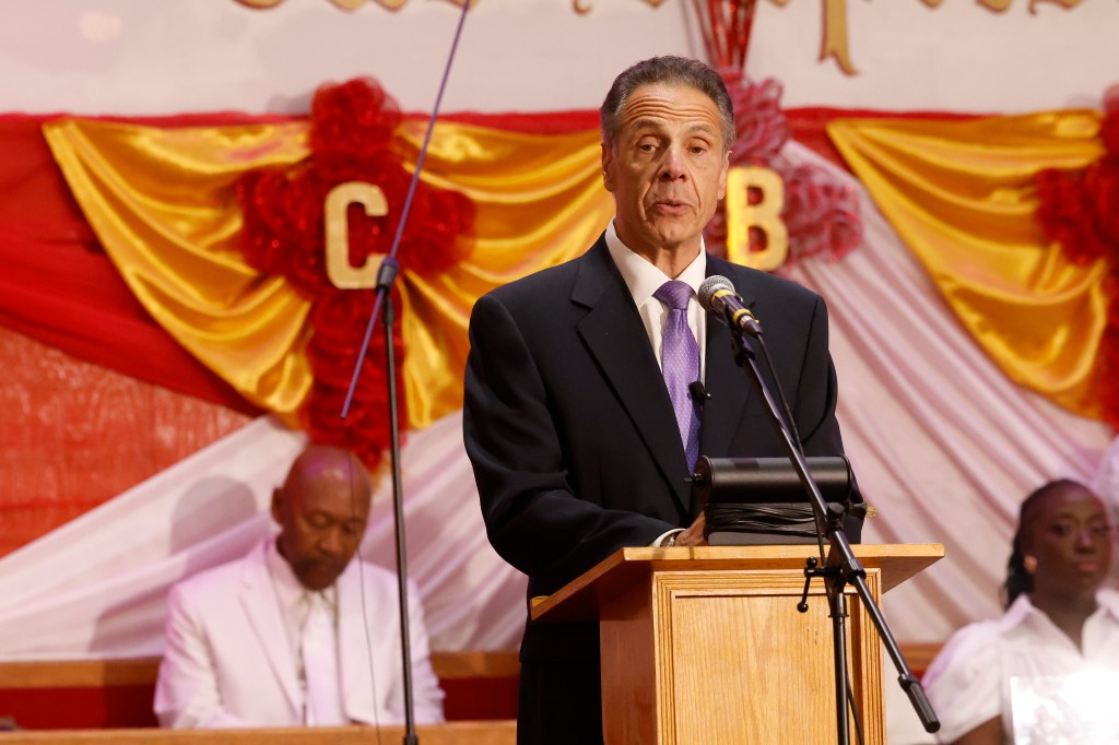 Andrew Cuomo speaking at a podium.