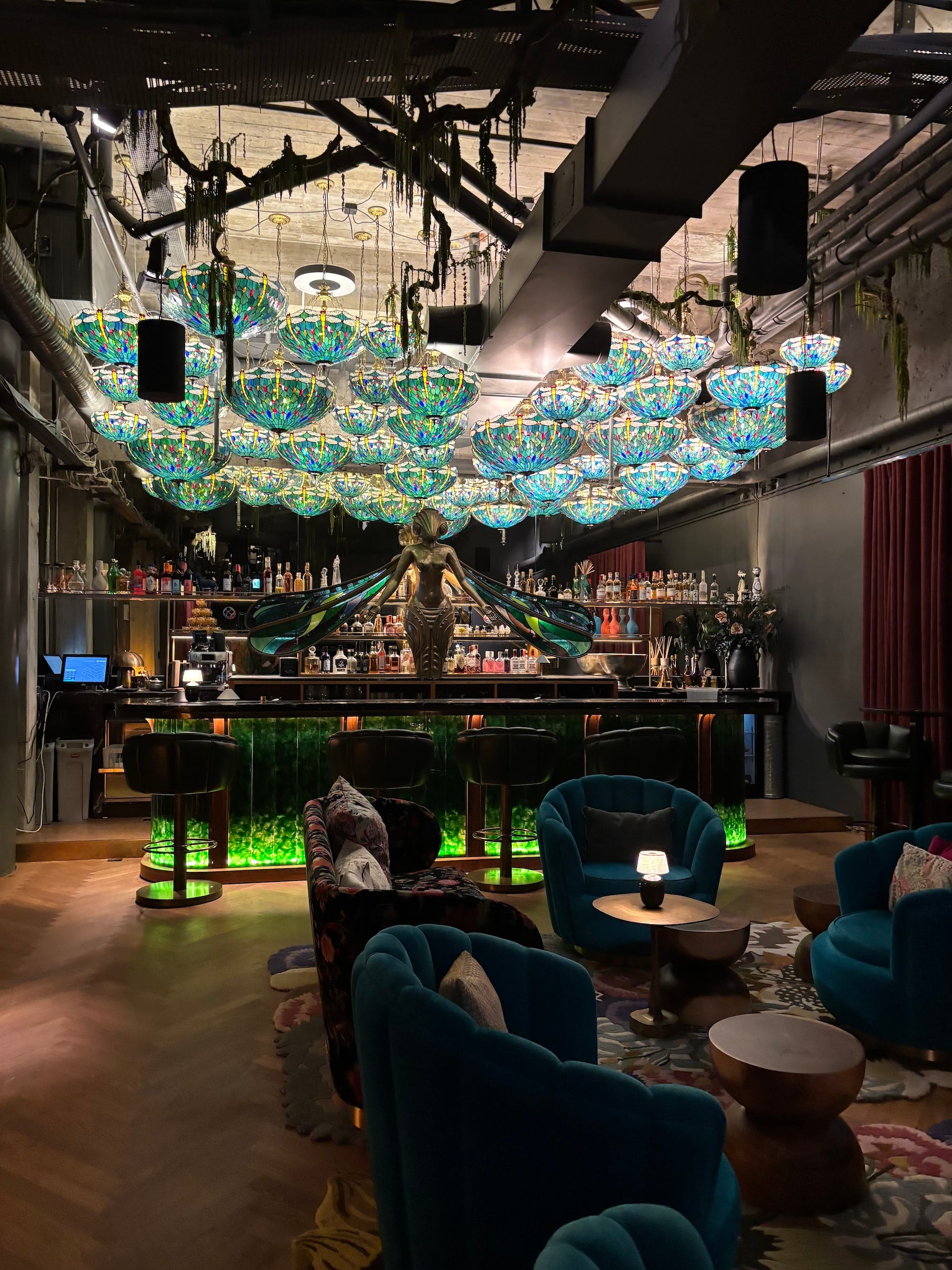 A bar with a statue of a moth and bright blue lights on the ceiling.