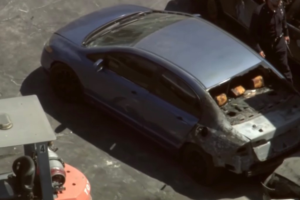 Burned-out car with two bodies inside.