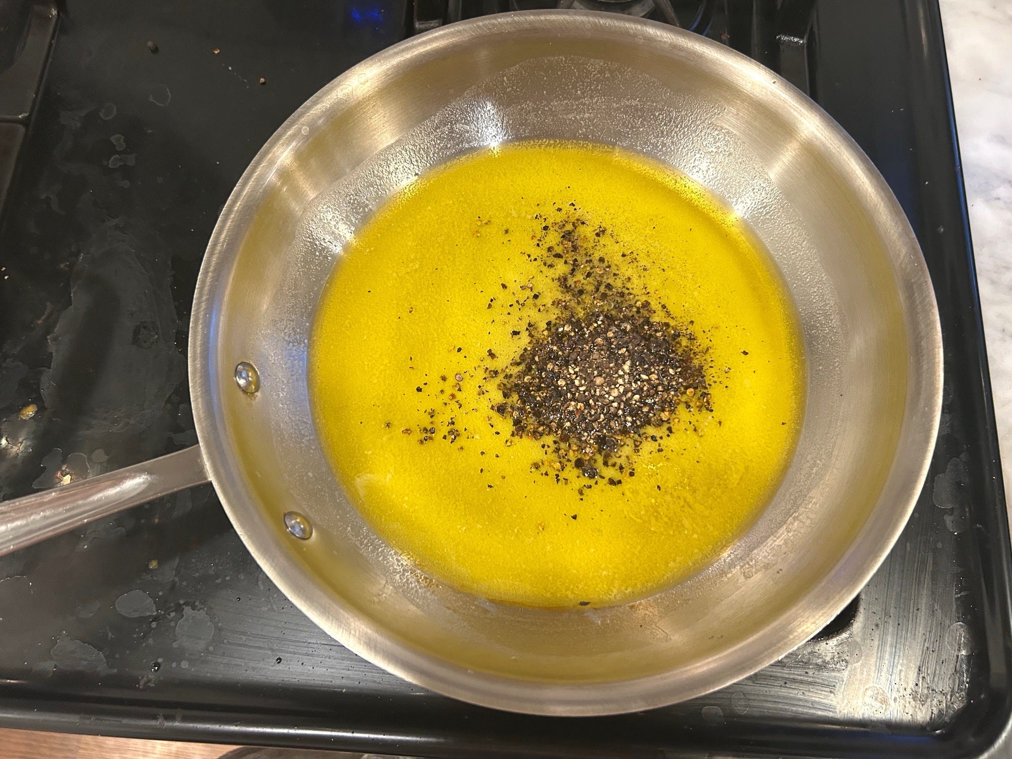 Adding peppercorns to the sauce for Gordon Ramsay's cacio e pepe