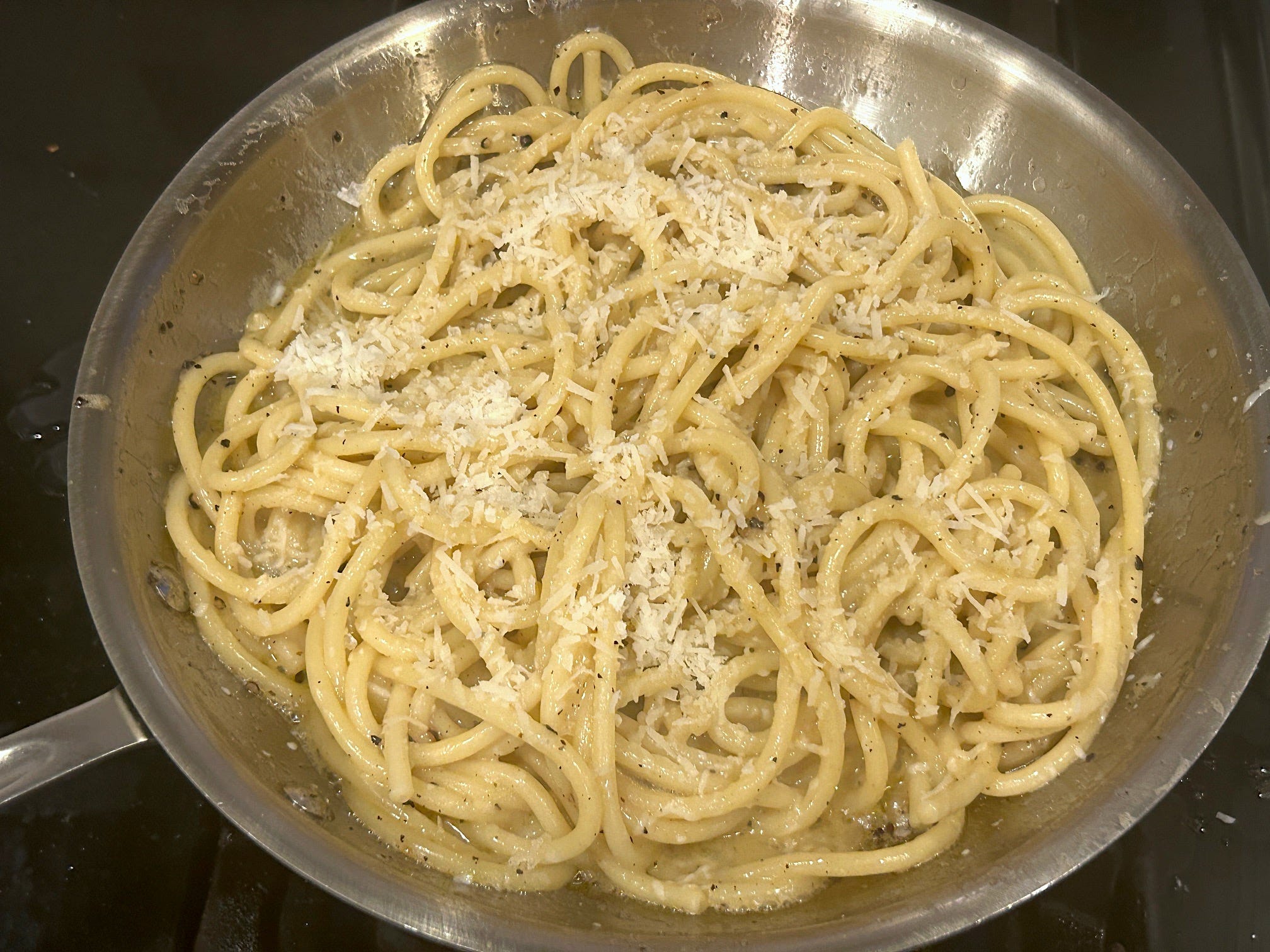 Adding cheese to the pasta and sauce for Gordon Ramsay's cacio e pepe