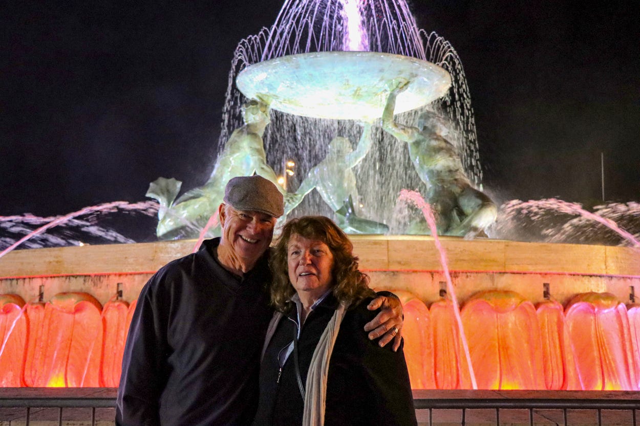 Mary Charlebois and Kevin Scanlon smiling at Triton's Fountain in Malt
