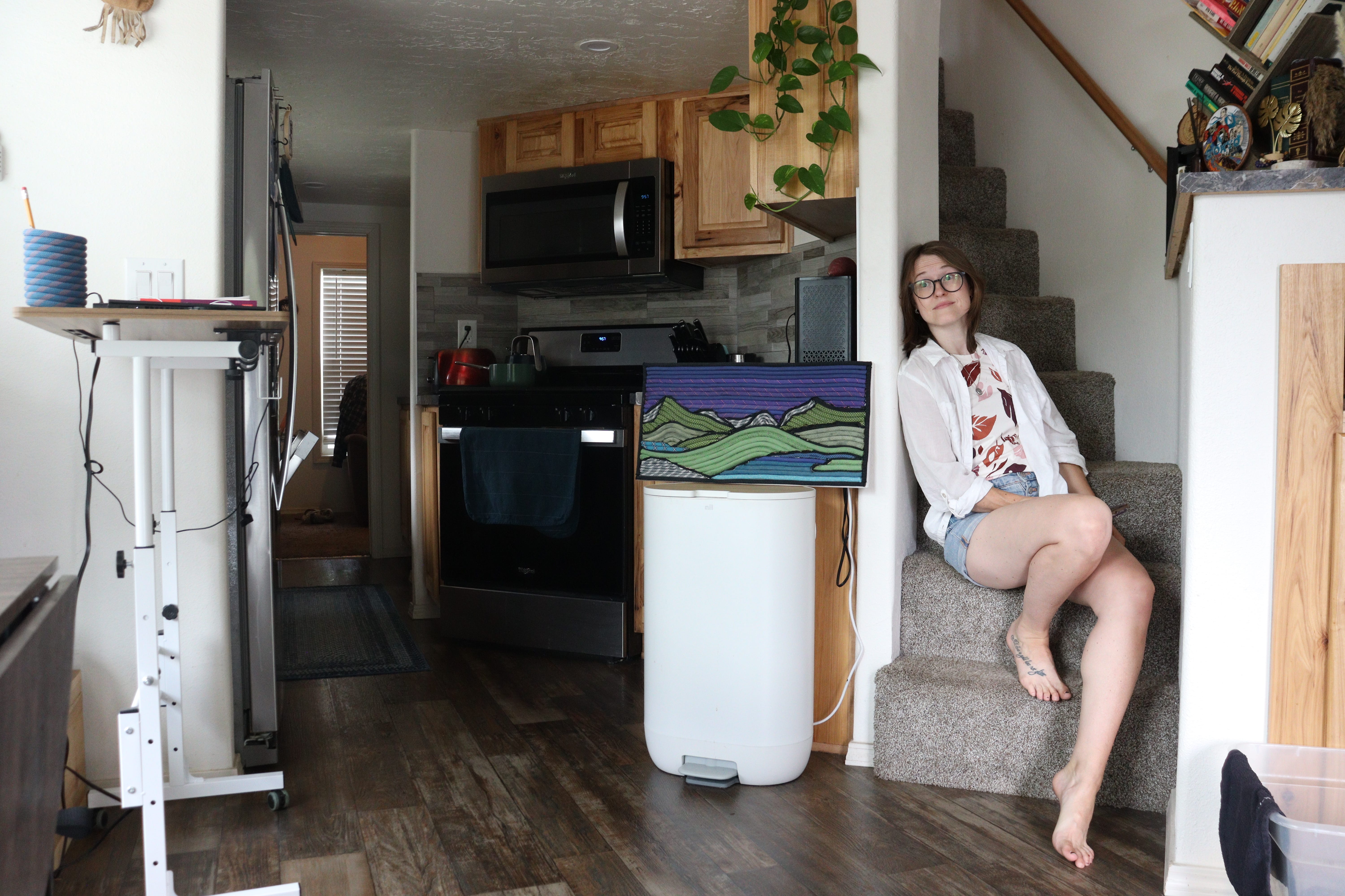 Author Amber McDaniel sitting inside tiny home on steps