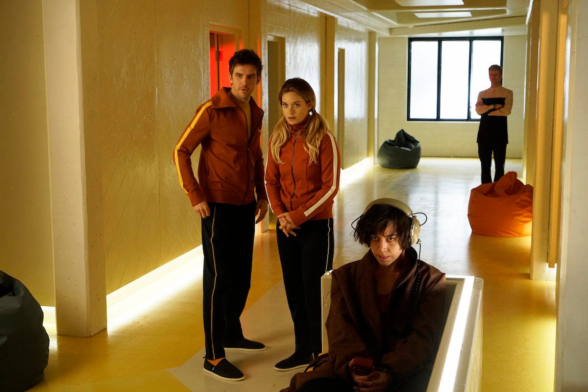 "Legion" stars, from left, Dan Stevens, Rachel Keller, and Aubrey Plaza, standing in a hallway in orange striped track suits.