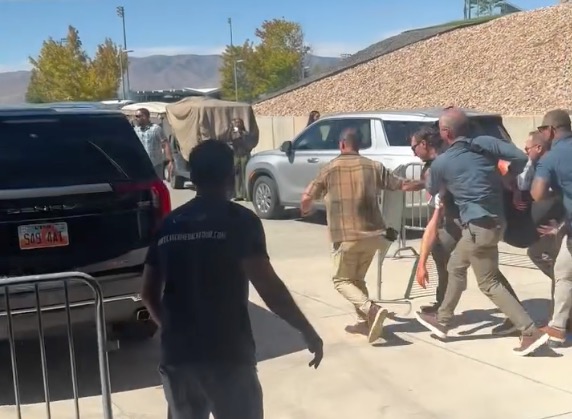 Charlie Kirk being escorted to a vehicle after a shooting.