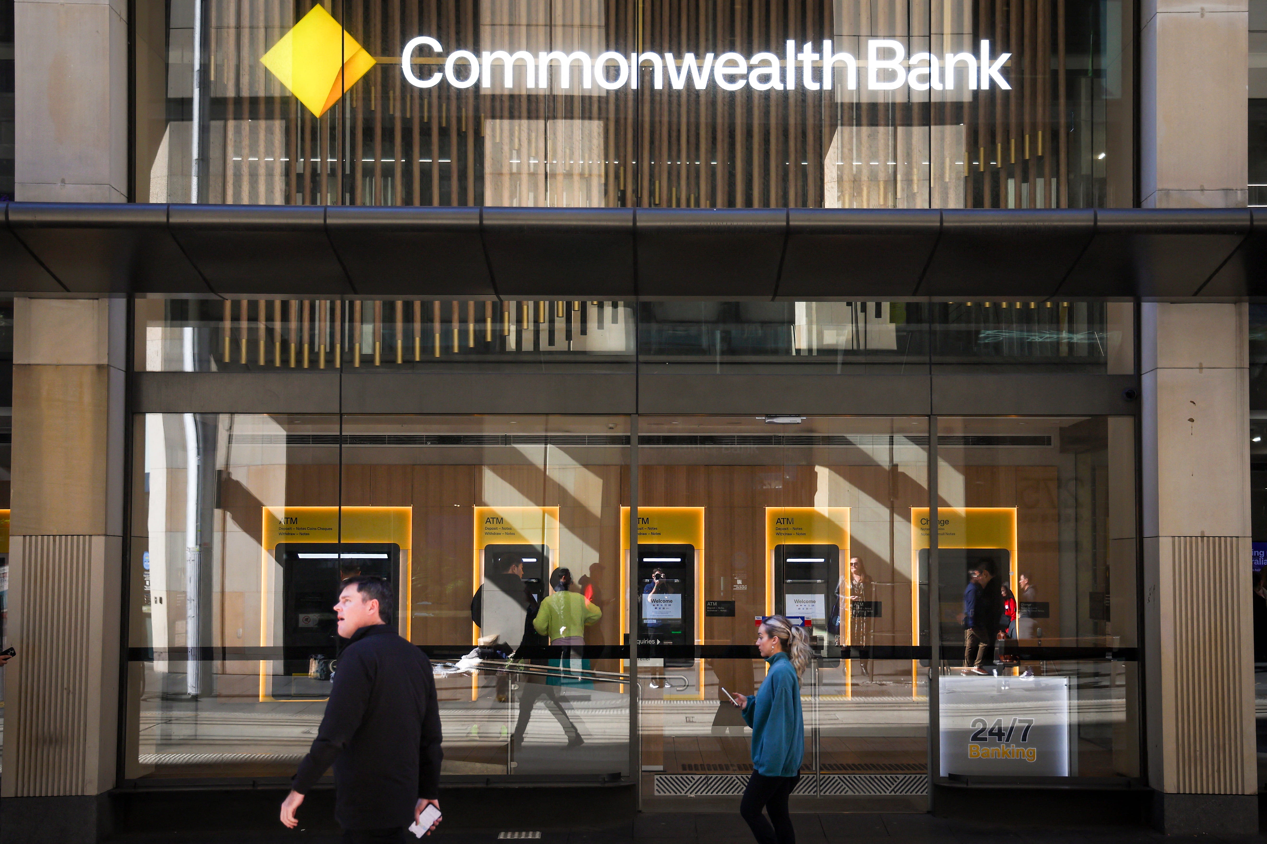 Pedestrians walk past a Commonwealth Bank of Australia (CBA) branch in central Sydney on August 13, 2025