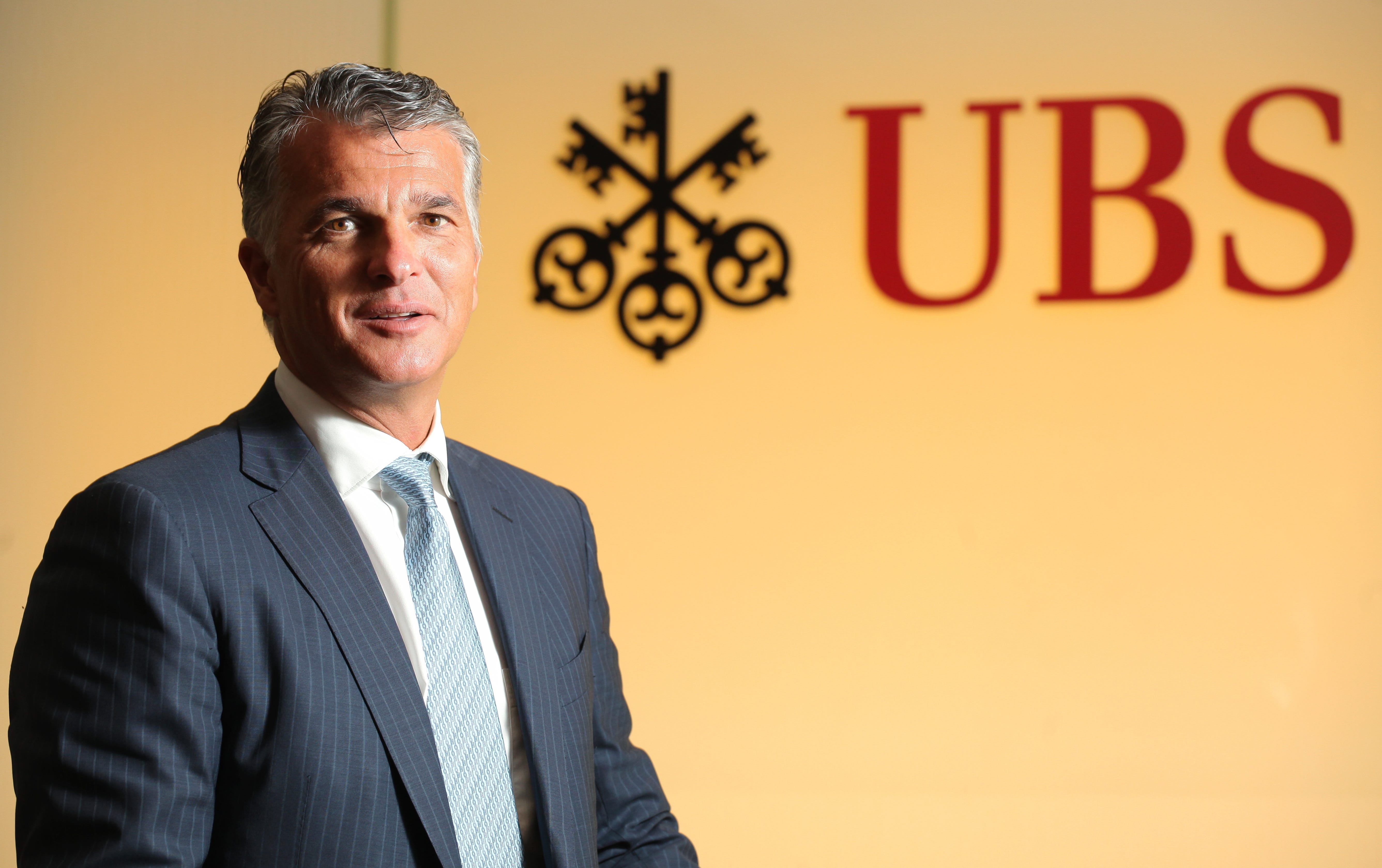 Sergio Ermotti, CEO of UBS with a UBS sign to the left of him