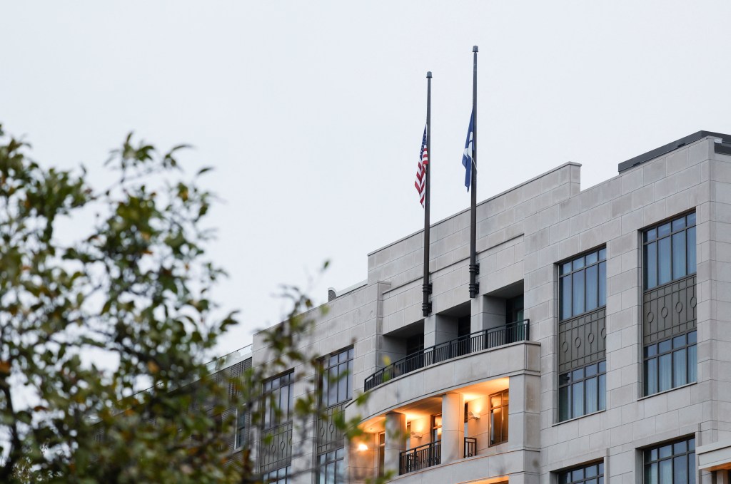 US and another flag at half-staff on a building.