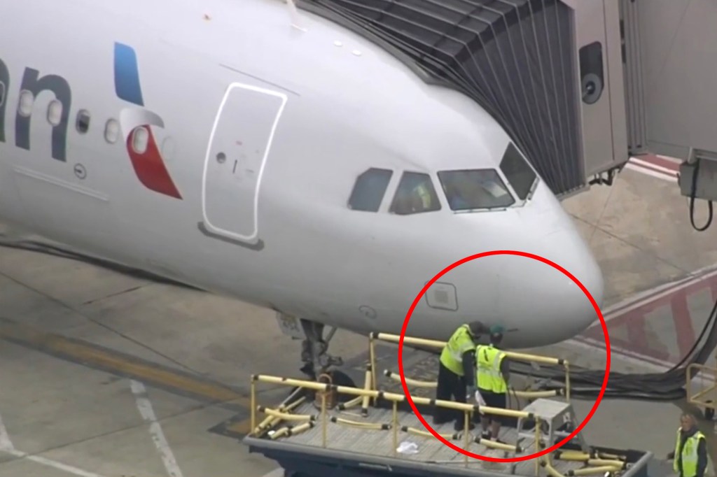 Ground crew inspecting the nose of an airplane.