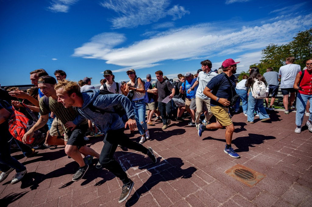 People fleeing the area after Kirk was shot while speaking at Utah Valley University.