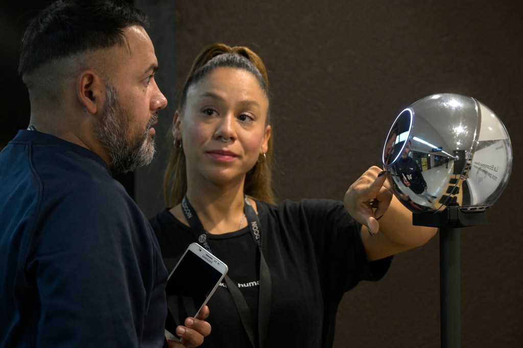 A person having their iris scanned by a Worldcoin orb.