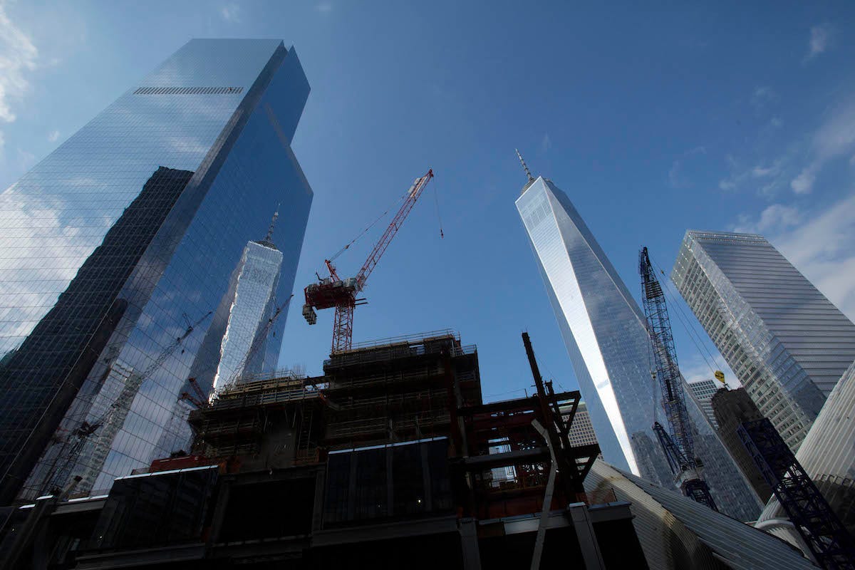 A construction crane works on top of the rising steel frame of Three World Trade Center, center, November 20, 2014 in New York. The neighboring skyscrapers are Four World Trade Center, left, One World Trade Center, second from right, and 7 World Trade Center, right.