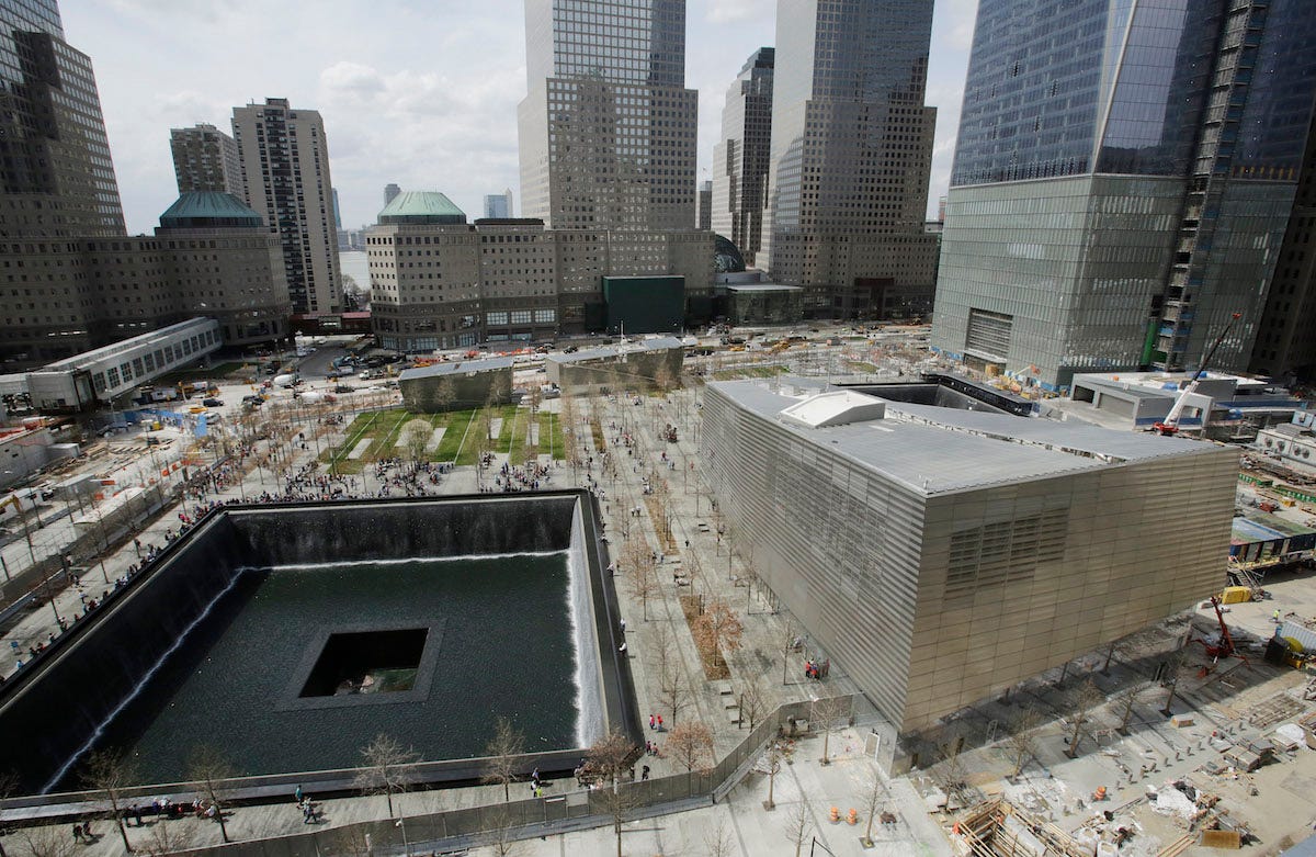 The September 11 Museum entrance pavilion, right, sits next to one of the September 11 Memorial pools, at the World Trade Center Monday, April 14, 2014 in New York. The memorial opened to the public in September, 2011 and the museum is scheduled to open in May, 2014.