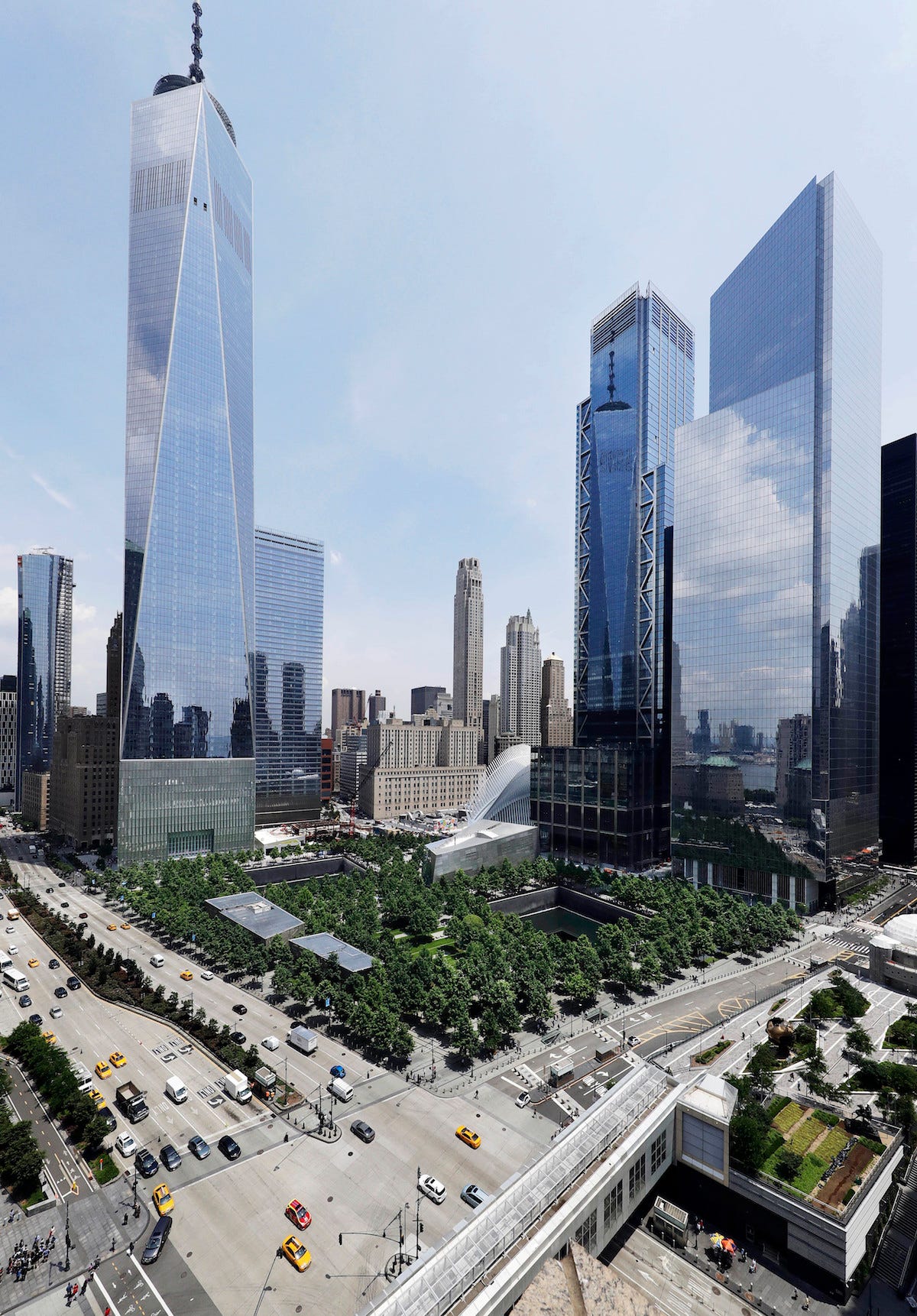 In this June 8, 2018 photo, 3 World Trade Center, second from right, joins its neighbors One World Trade Center, left, and 4 World Trade Center, right, next to the September 11 Memorial and Museum in New York. The center's latest skyscraper opens Monday.