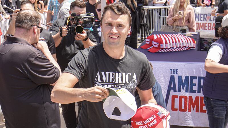 Charlie Kirk, founder of Turning Point USA, throws hats to the public at Utah event.
