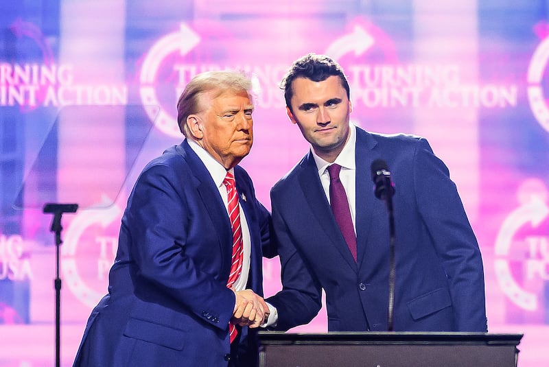 Charlie Kirk (R) speaks on stage with President Donald Trump at America Fest 2024 in Phoenix, Arizona, on December 22, 2024.