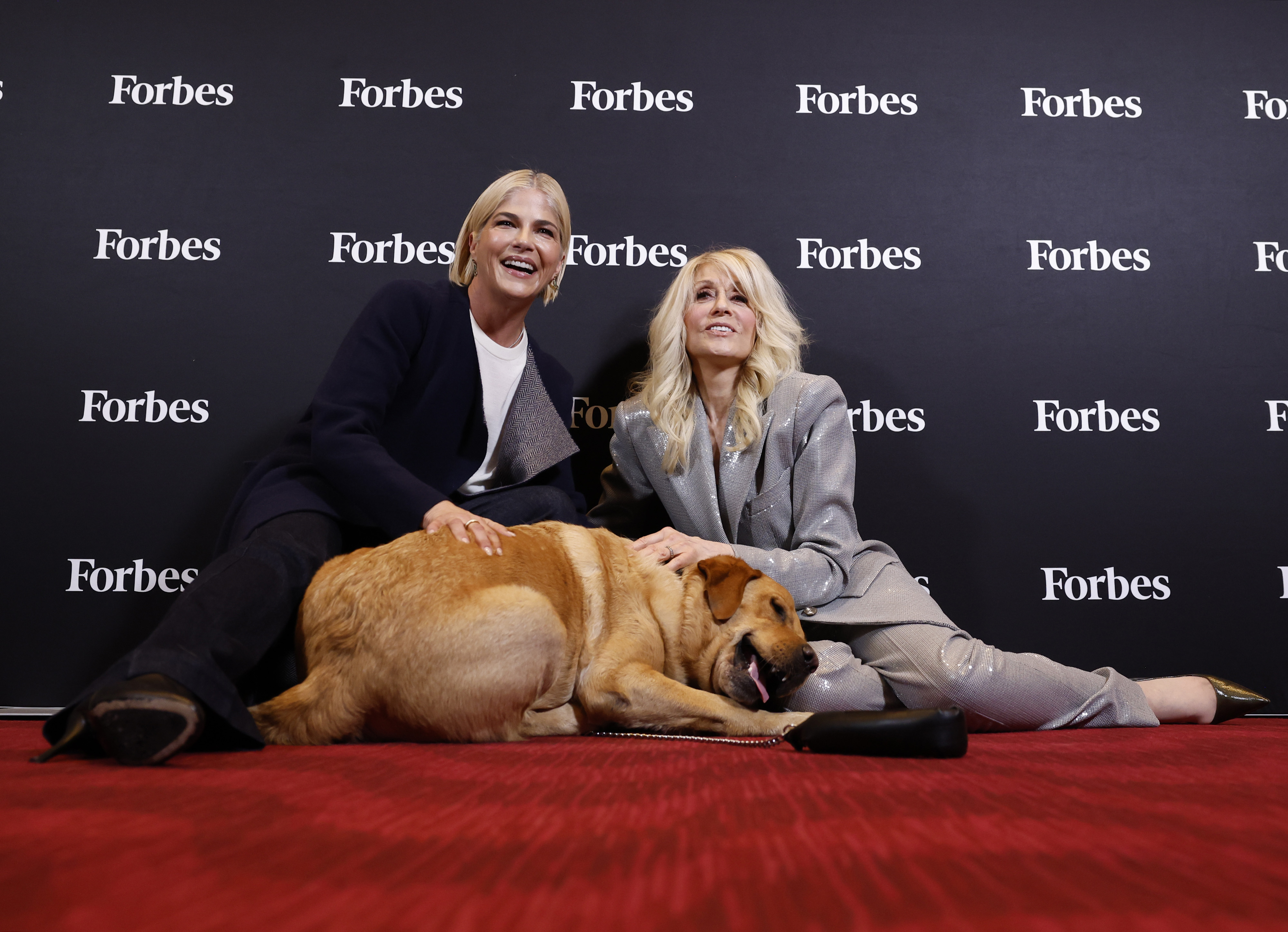 Judith Light and Selma Blair pose on the floor with Blair's dog Scout at the Forbes Power Women's Summit in NYC.