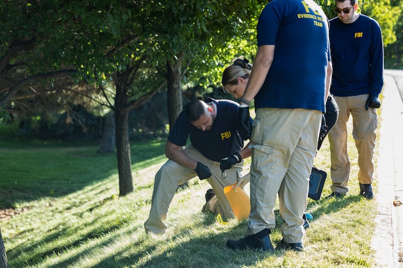 Law enforcement officials, including members of an FBI forensics team, investigate woods on September 11, 2025 near the crime scene where political activist Charlie Kirk was shot and killed at Utah Valley University in Orem, Utah, the day prior.