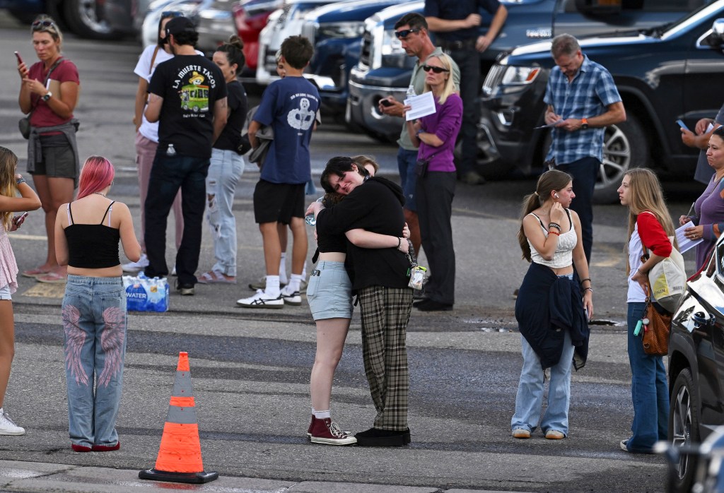 Students embrace outside a school after a shooting.