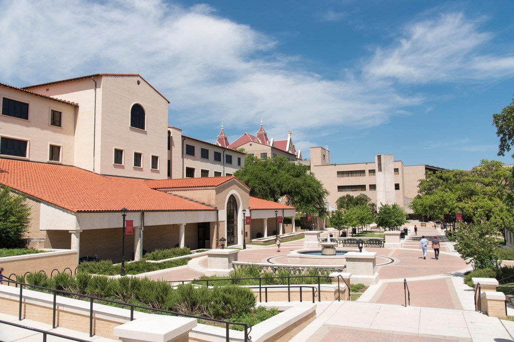 University campus courtyard with buildings and students.