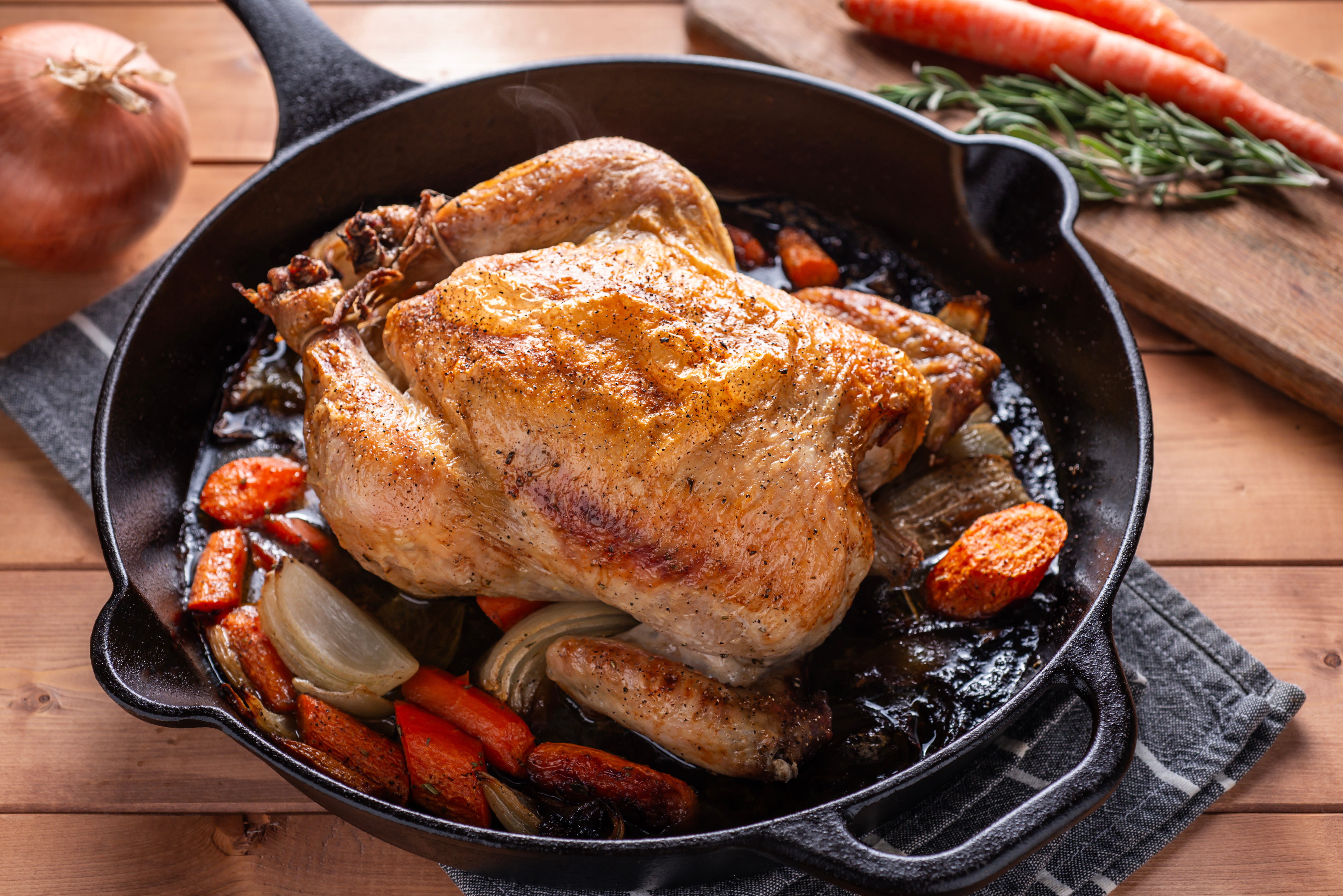 Skillet with roast chicken and vegetables inside.