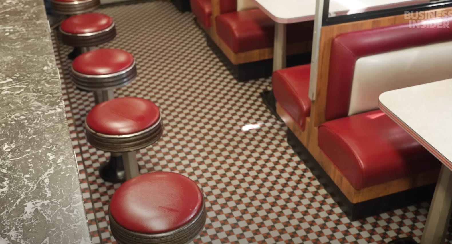 Summit Diner's tile flooring, red bar stools, and black marble countertop.