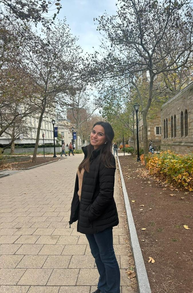 Alegria Silvi, a college student, smiling outdoors.