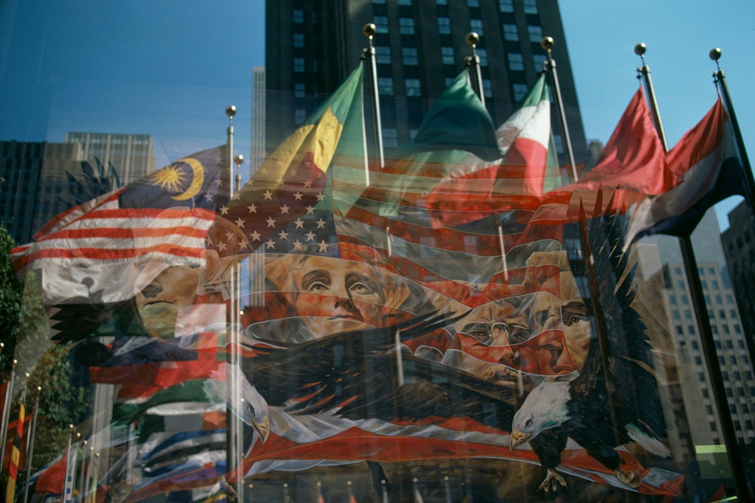 A painting of Mount Rushmore and an eagle combined with a view of various flags.