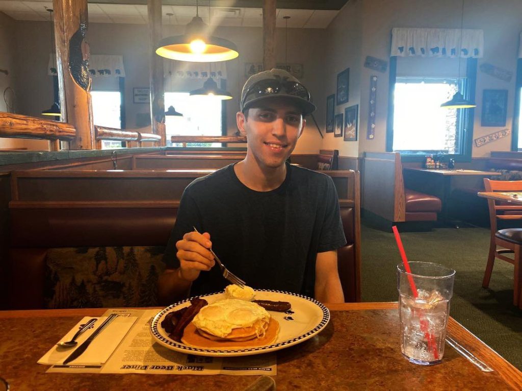 Tyler Robinson, 22, eating breakfast at a restaurant.
