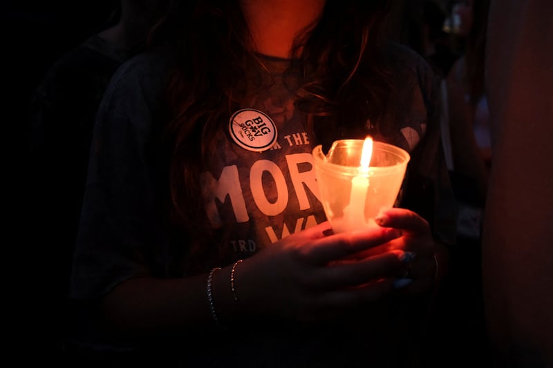 A candle illuminating a t-shirt saying big gov sucks and Mor