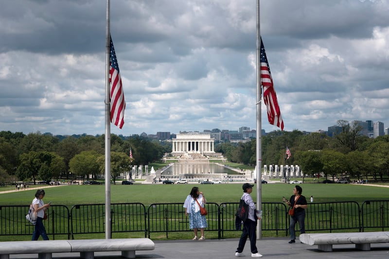 Two US flags at half staff in front of the Lincoln memorial