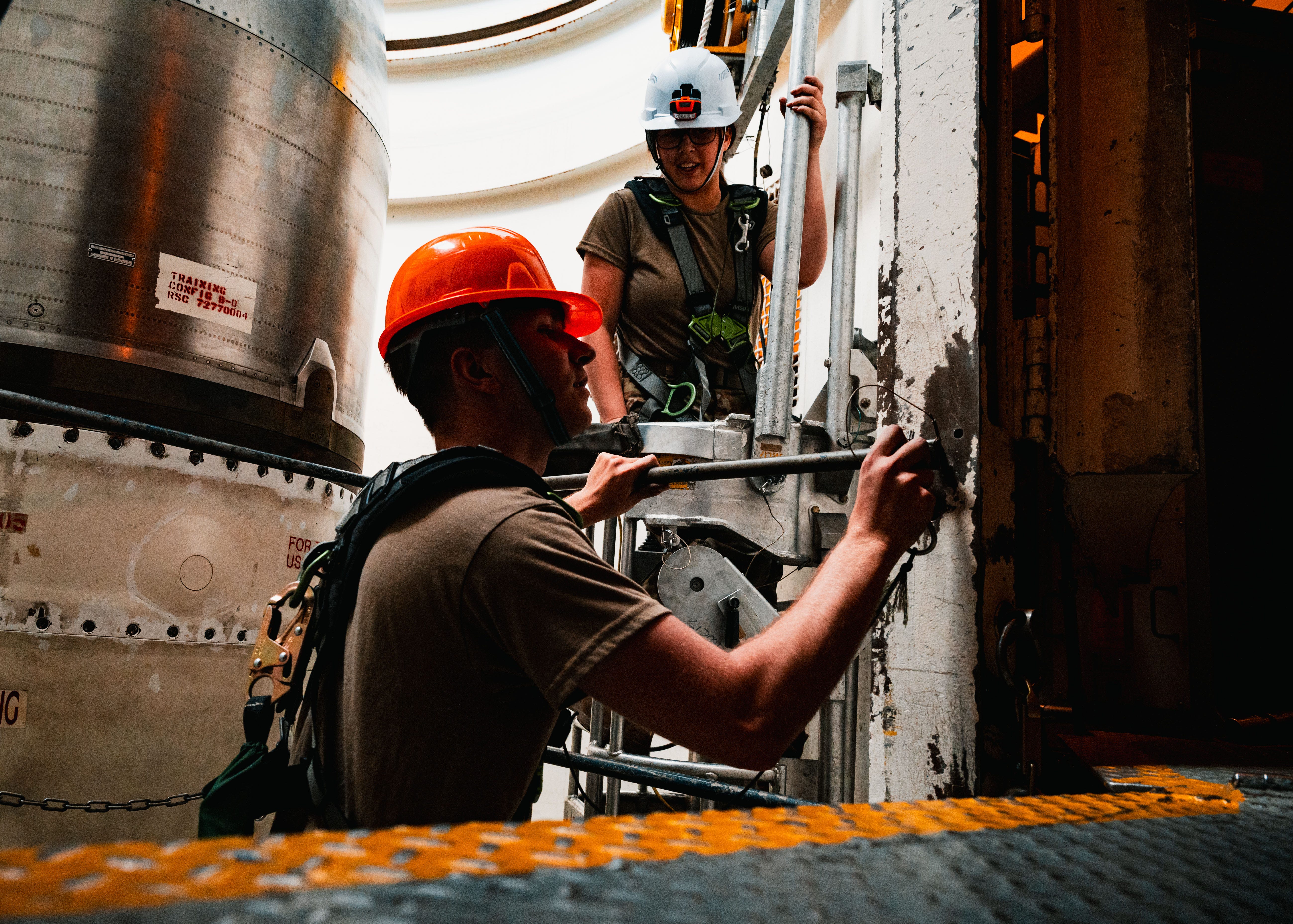 Two US Air Force Airmen work on maintenance within a missile silo.