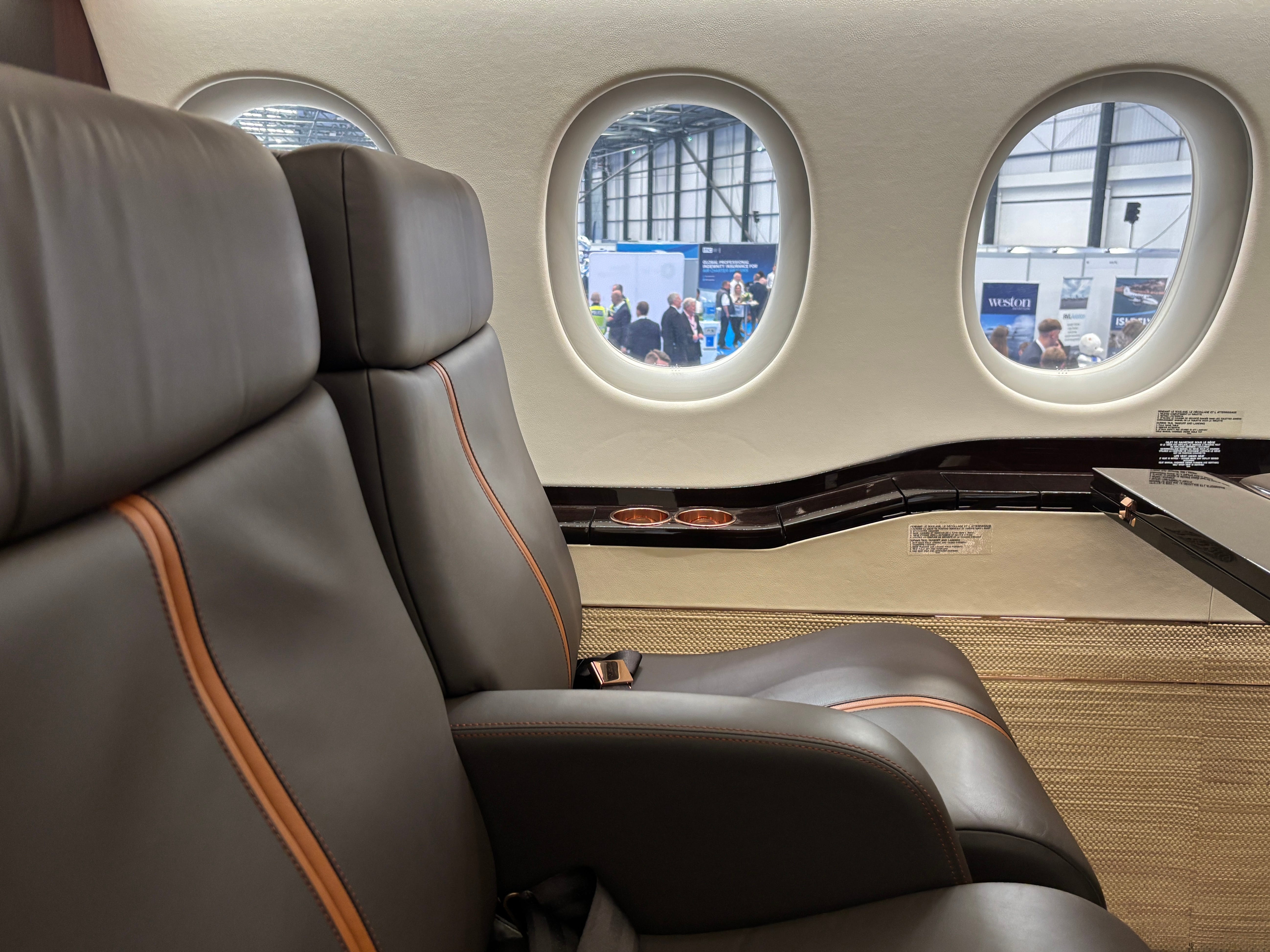 A closeup of two seats and the view out the window on board a Dassault Falcon 8X on display at the 2025 Air Charter Expo
