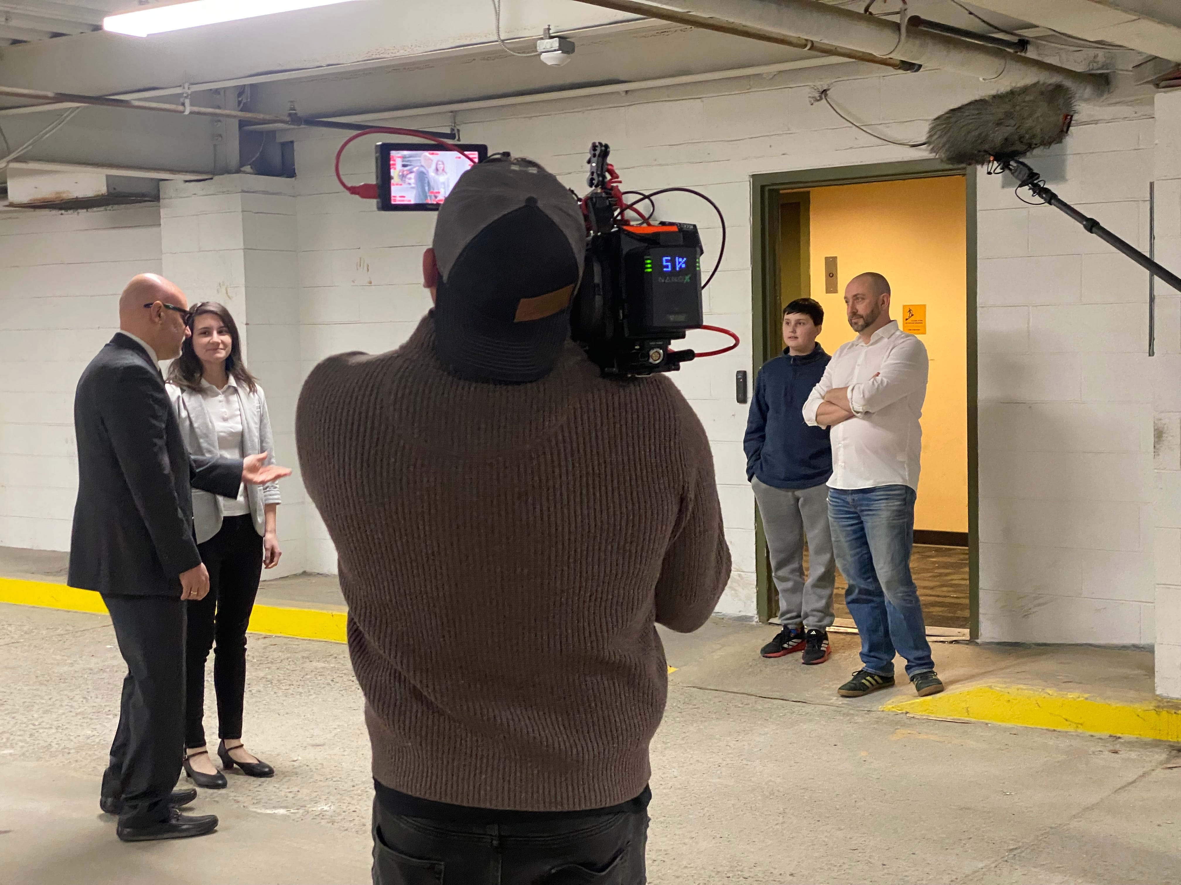 A camera crew gathers in an empty space