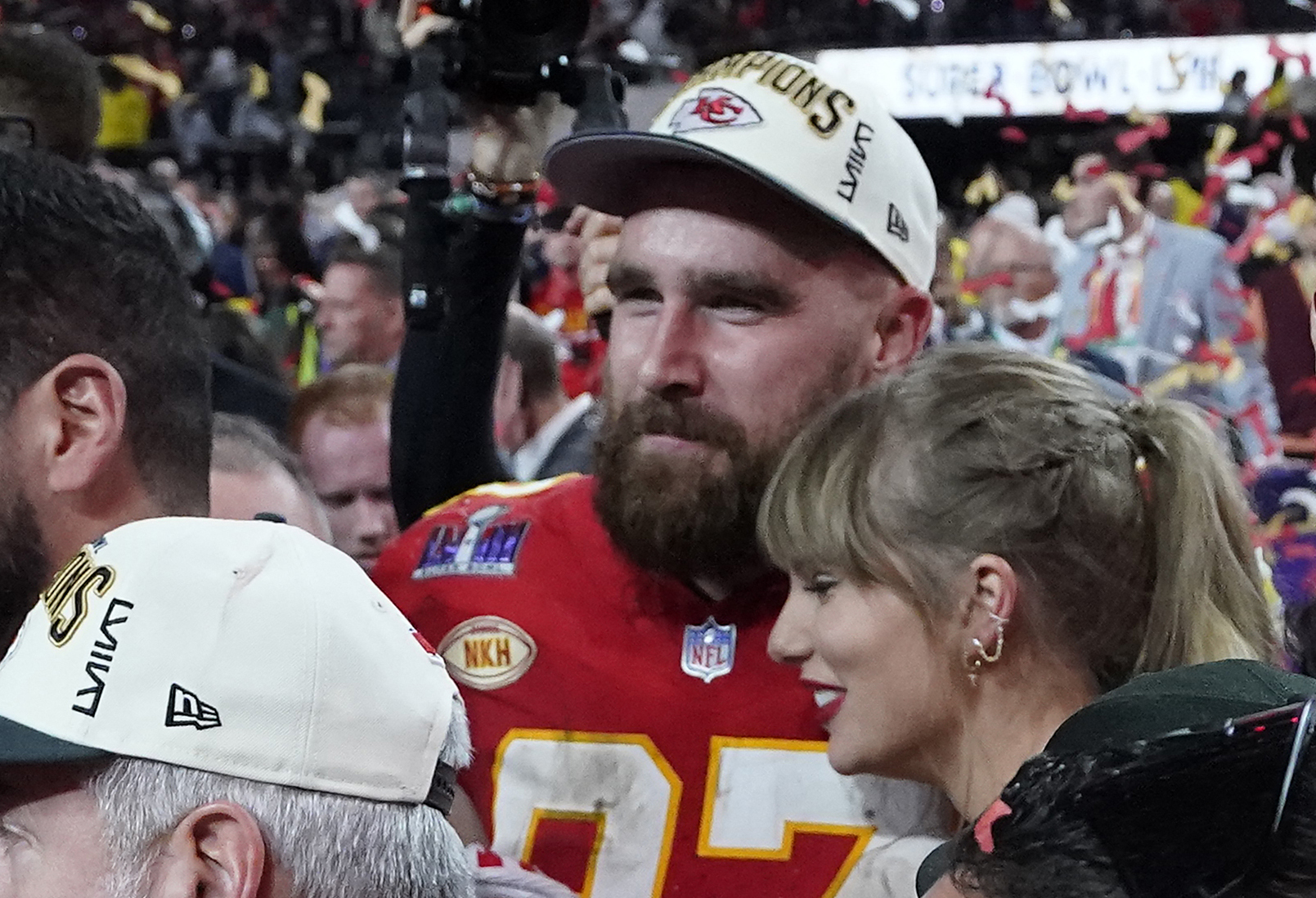 Taylor Swift hugging Travis Kelce on a football field