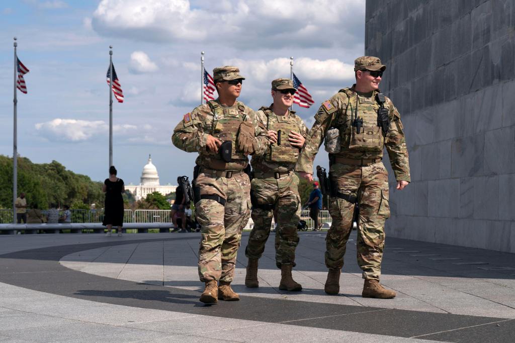 Three Louisiana National Guard members patrol near the Washington Monument.