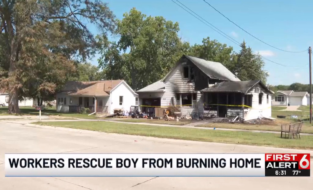 Burned house with rescue workers.
