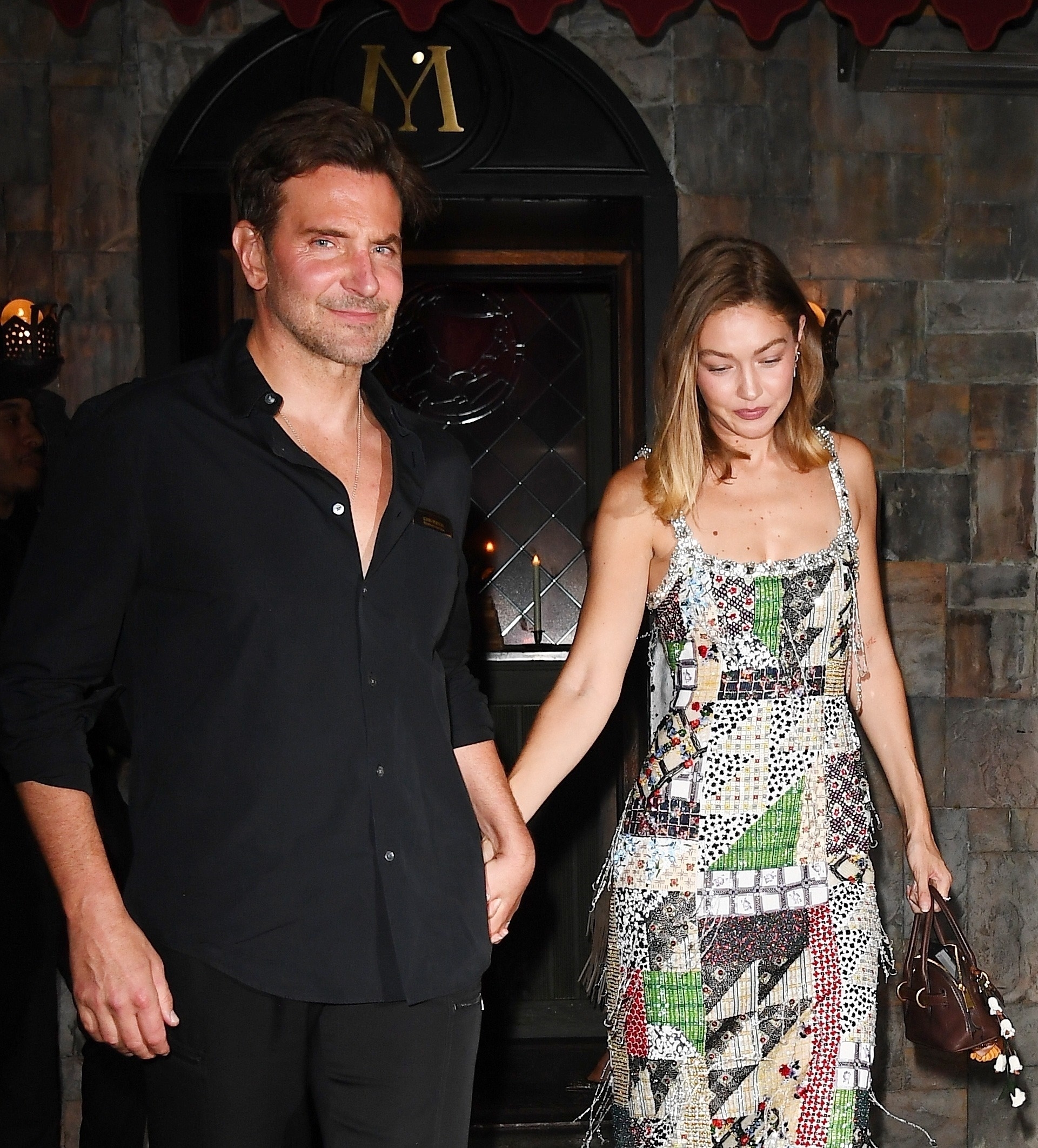 Bradley Cooper and Gigi Hadid walk hand in hand while the Vogue October issue cocktail party at Monsieur.