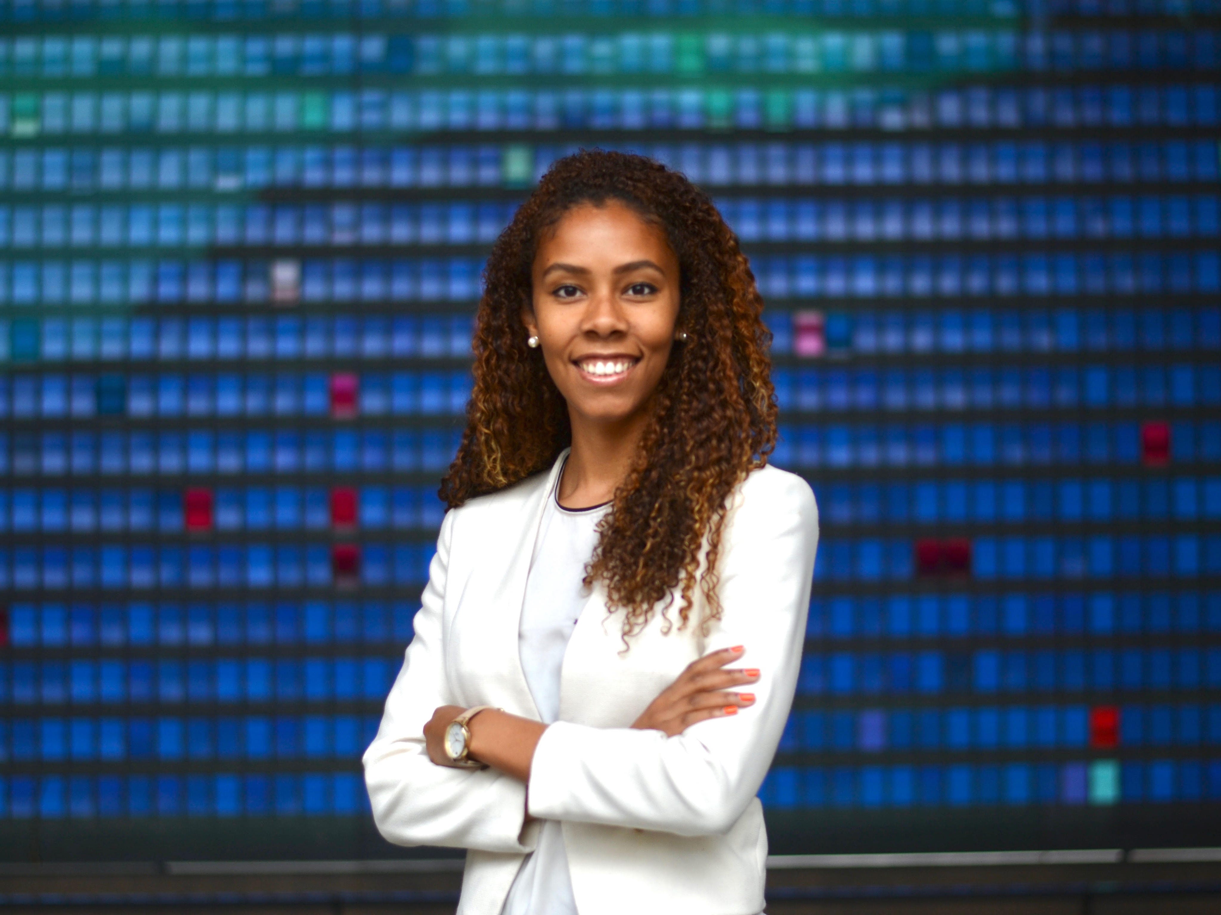 Mercedes Bent, partner at Lightspeed Venture Partners, wearing white suit in front of blue tiled background.