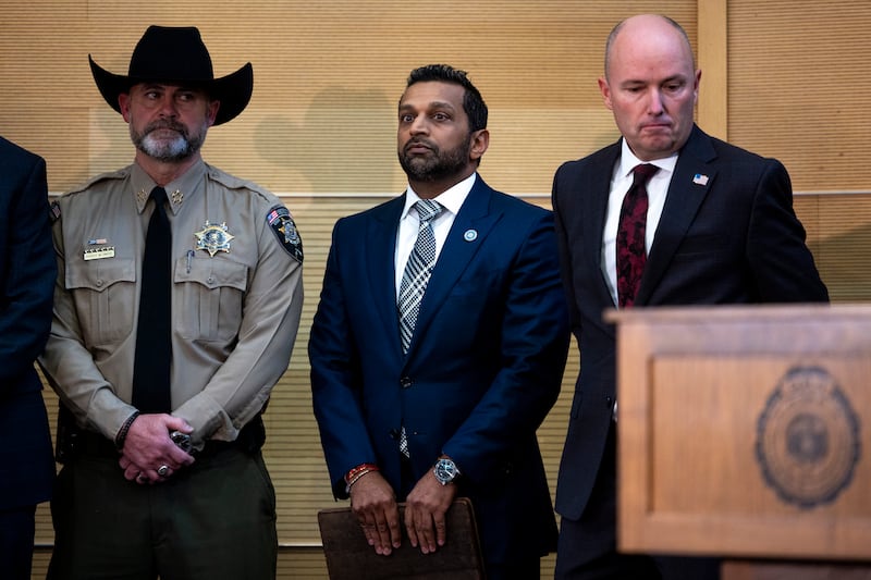 FBI director Kash Patel (C) stands with Utah Gov. Spencer Cox (R) before speaking at a press conference on September 12, 2025 in Orem, Utah.
