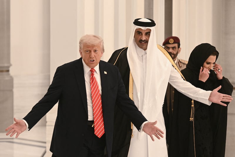 TOPSHOT - Qatar's Emir Sheikh Tamim bin Hamad al-Thani (C), accompanied by his spouse Sheikha Jawaher (R), and US President Donald Trump (L) arrive to greet guests ahead of a state dinner at the Lusail Palace in Doha on May 14, 2025. (Photo by Brendan SMIALOWSKI / AFP) (Photo by BRENDAN SMIALOWSKI/AFP via Getty Images)