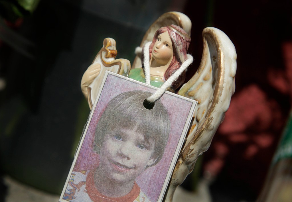 Photo of Etan Patz's picture hanging on an angel figurine.