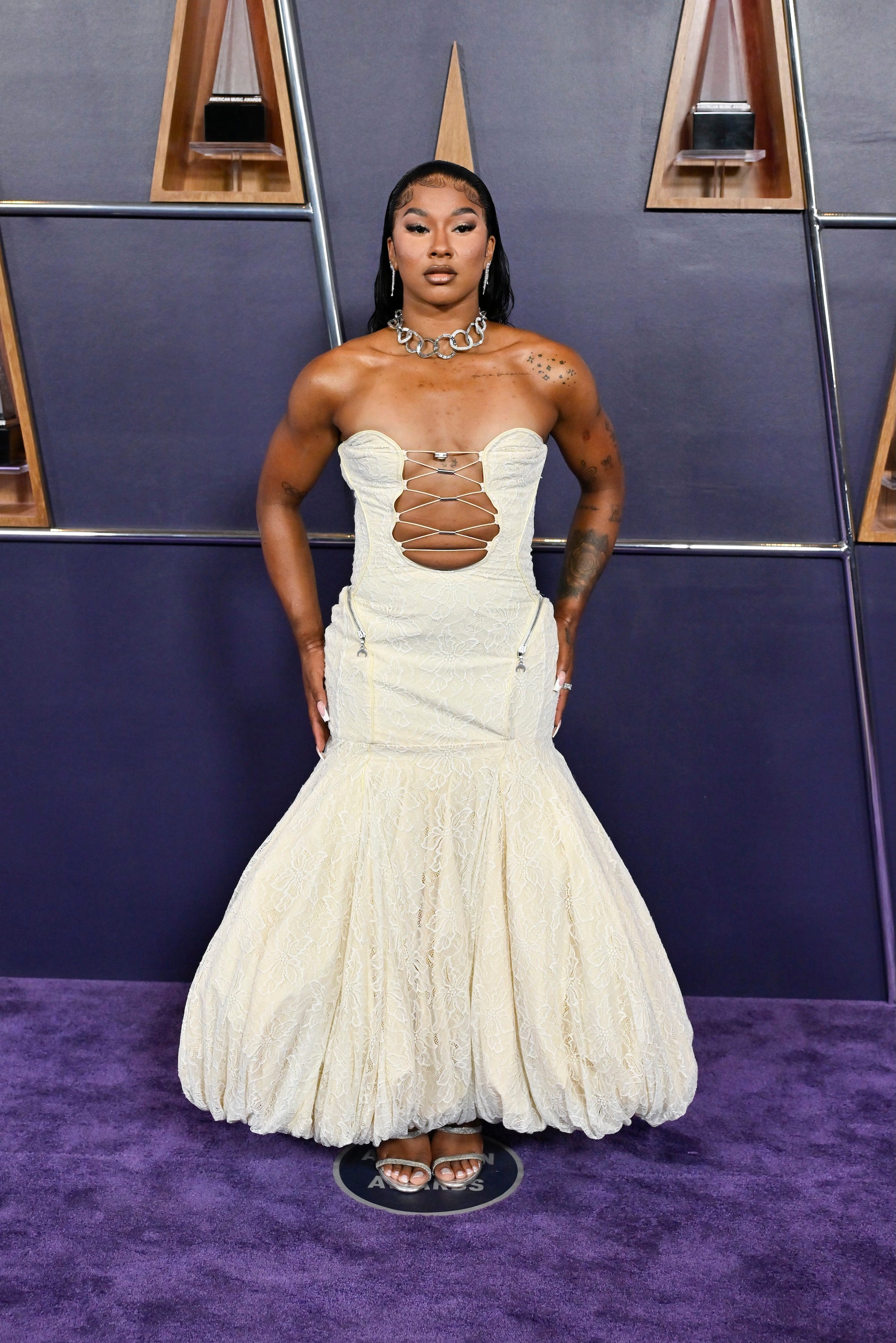 Jordan Chiles poses on a purple carpet ahead of the 2025 American Music Awards.