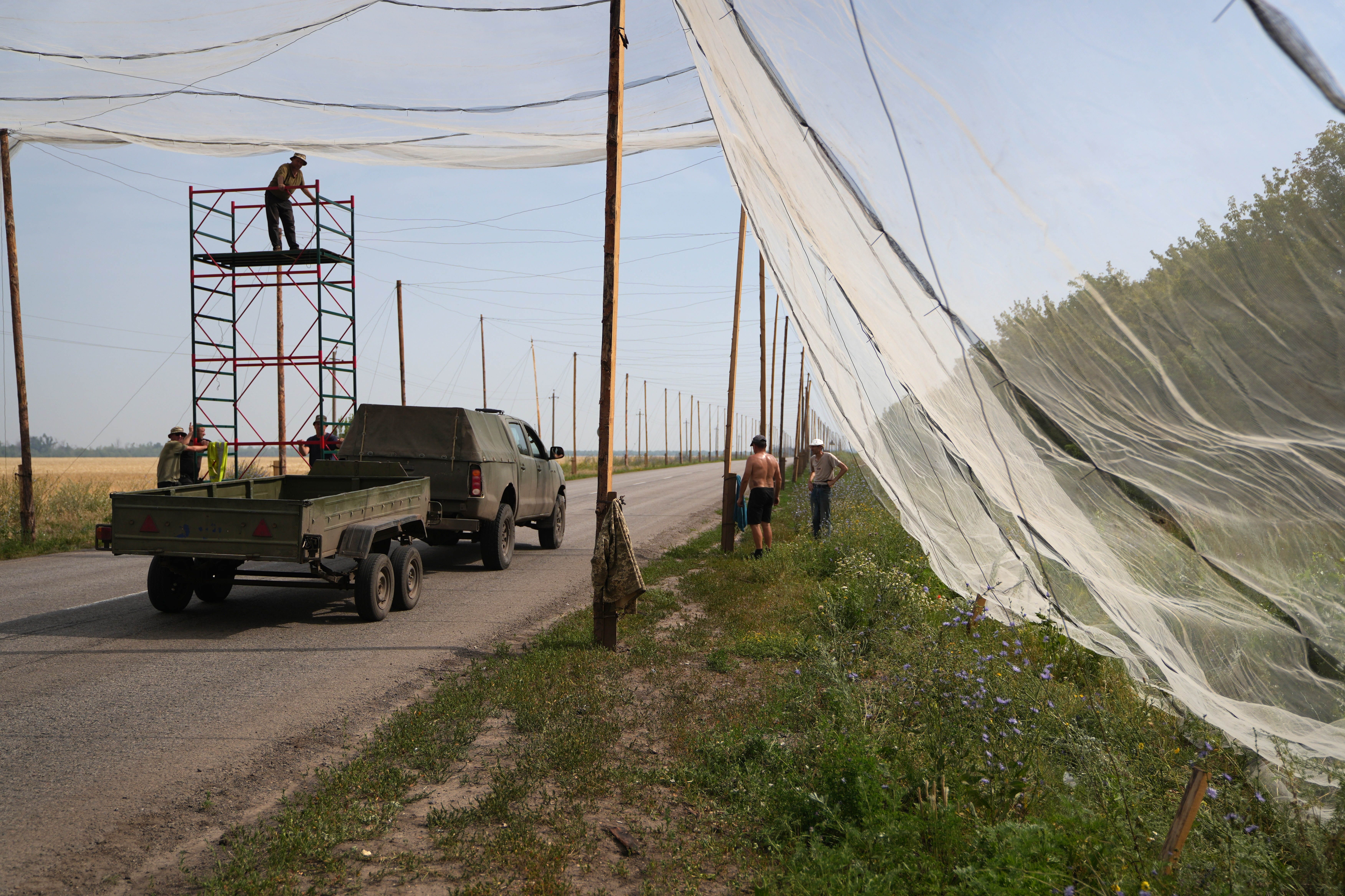 July 12, 2025, Donbass, Ukraine: Ukrainian army soldiers install protective nets against Russian drones on a road between Kramatorsk and Dobropillia to prevent attacks of FPV drones with bombs.