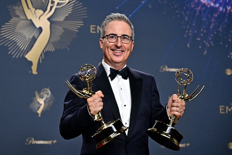 British television host John Oliver poses in the press room with the awards for Outstanding Writing for a Variety Series and Outstanding Scripted Variety Series award for "Last Week Tonight With John Oliver" during the 77th Primetime Emmy Awards at the Peacock Theatre at LA Live in Los Angeles on September 14, 2025. (Photo by Frederic J. Brown / AFP) / RESTRICTED TO EDITORIAL USE (Photo by FREDERIC J. BROWN/AFP via Getty Images)
