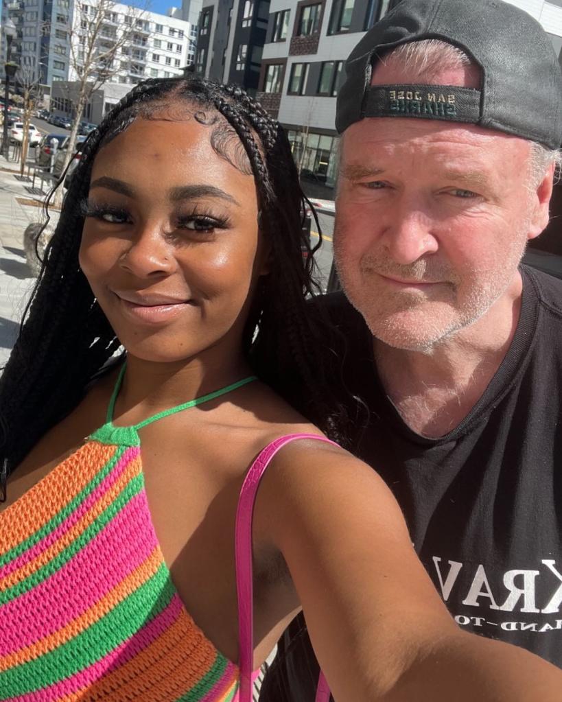 Photo of a young woman and an older man posing for a selfie.