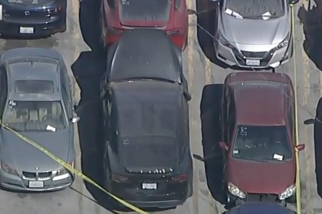 Aerial view of several cars in a parking lot, some marked with yellow tape.