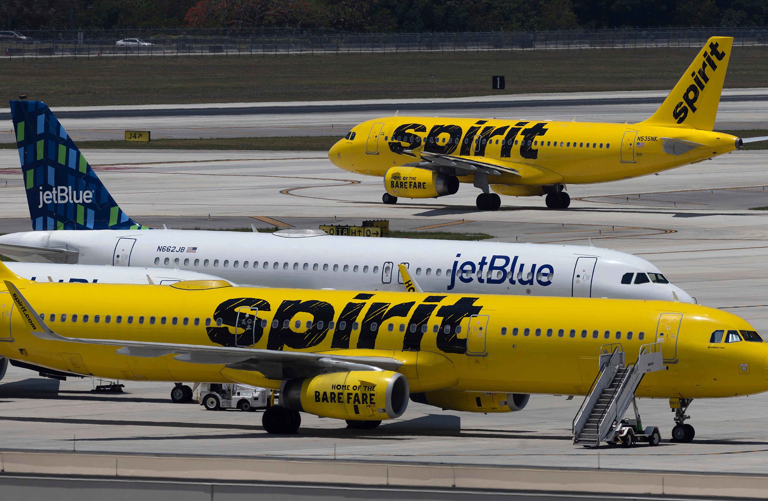 A JetBlue Airlines plane is seen near Spirit Airlines planes at the Fort Lauderdale-Hollywood International Airport on May 16, 2022 in Fort Lauderdale, Florida